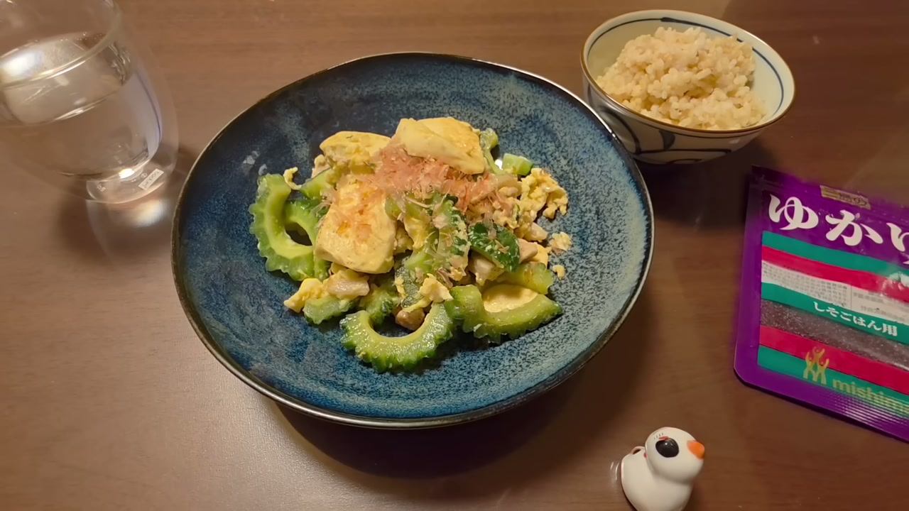 青い器に盛ったゴーヤチャンプルーとごはん。チャンネル最初の動画より